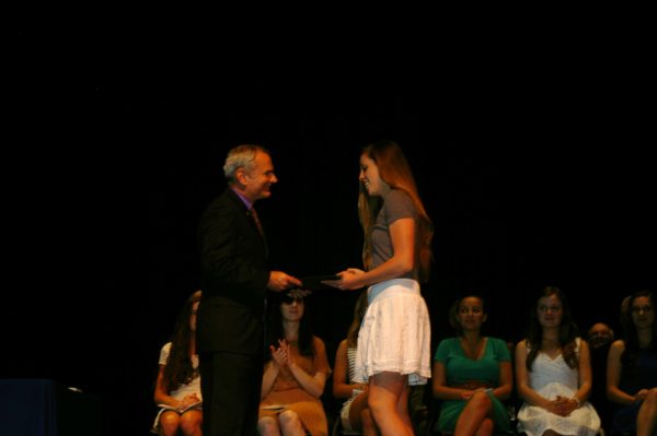 Michaela receiving the scholarship from Eric's dad.